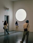 Three people in a gallery