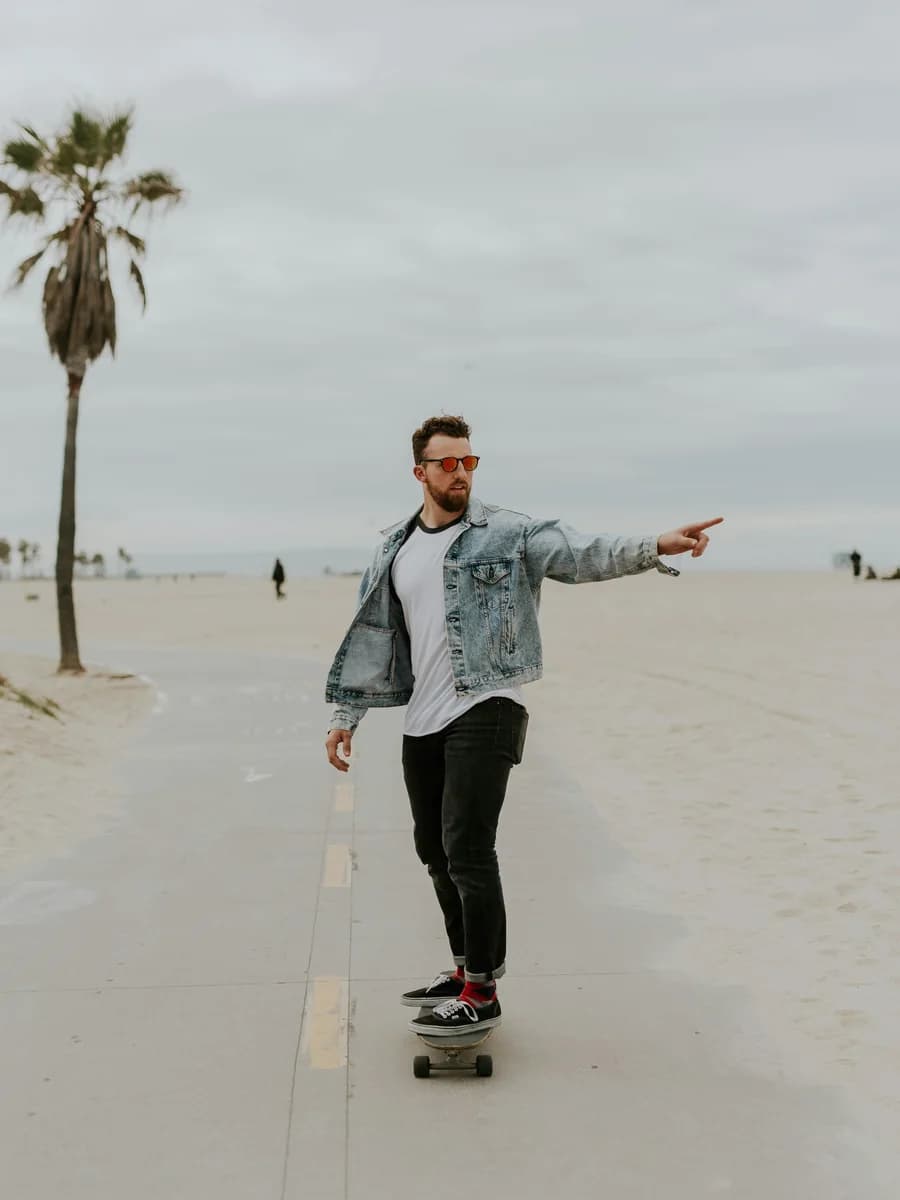 A picture of a skateboarder rolling along a seafront path.